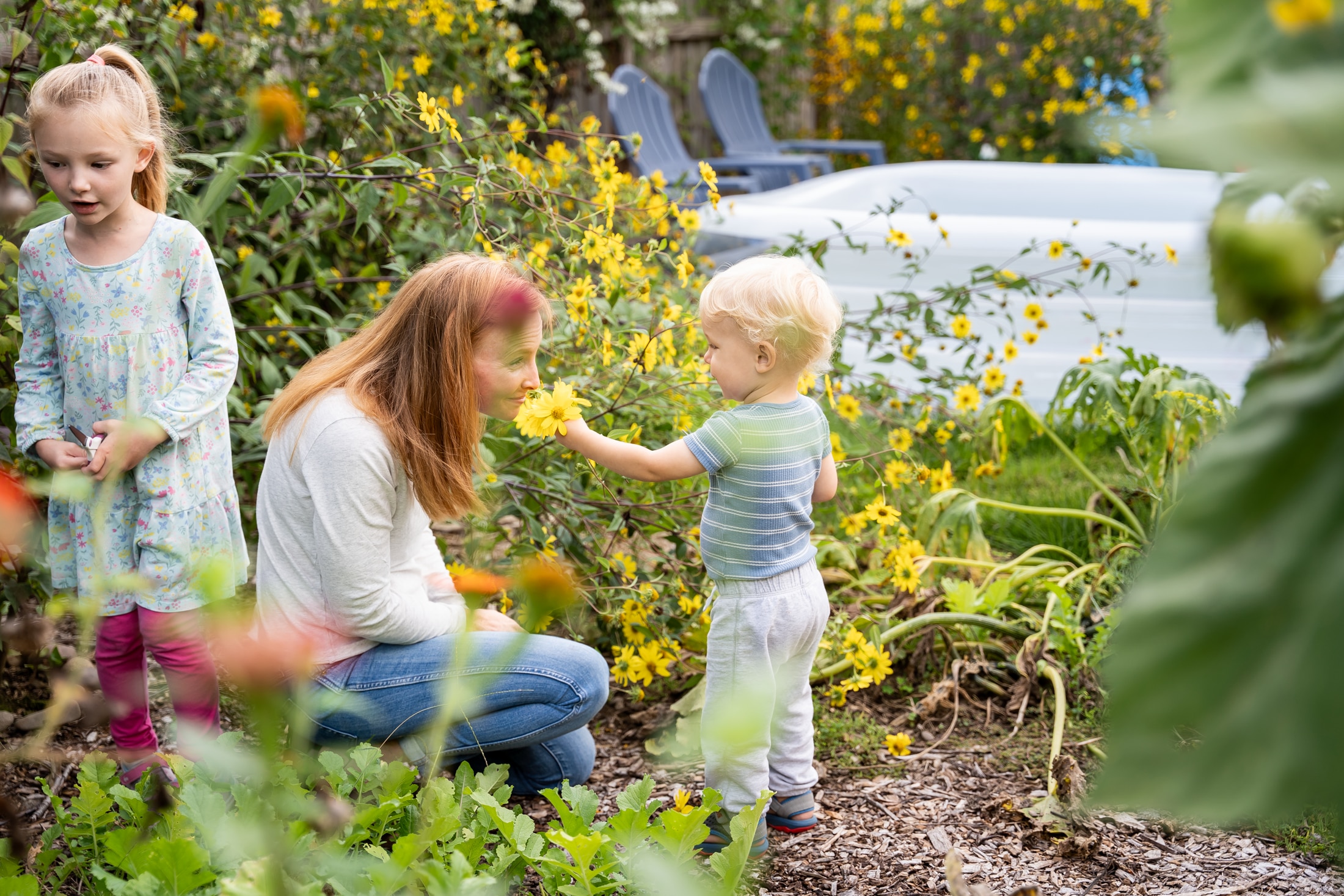 Flower power: Jancey's little girl adorning her parents with backyard blooms, the epitome of family fun.