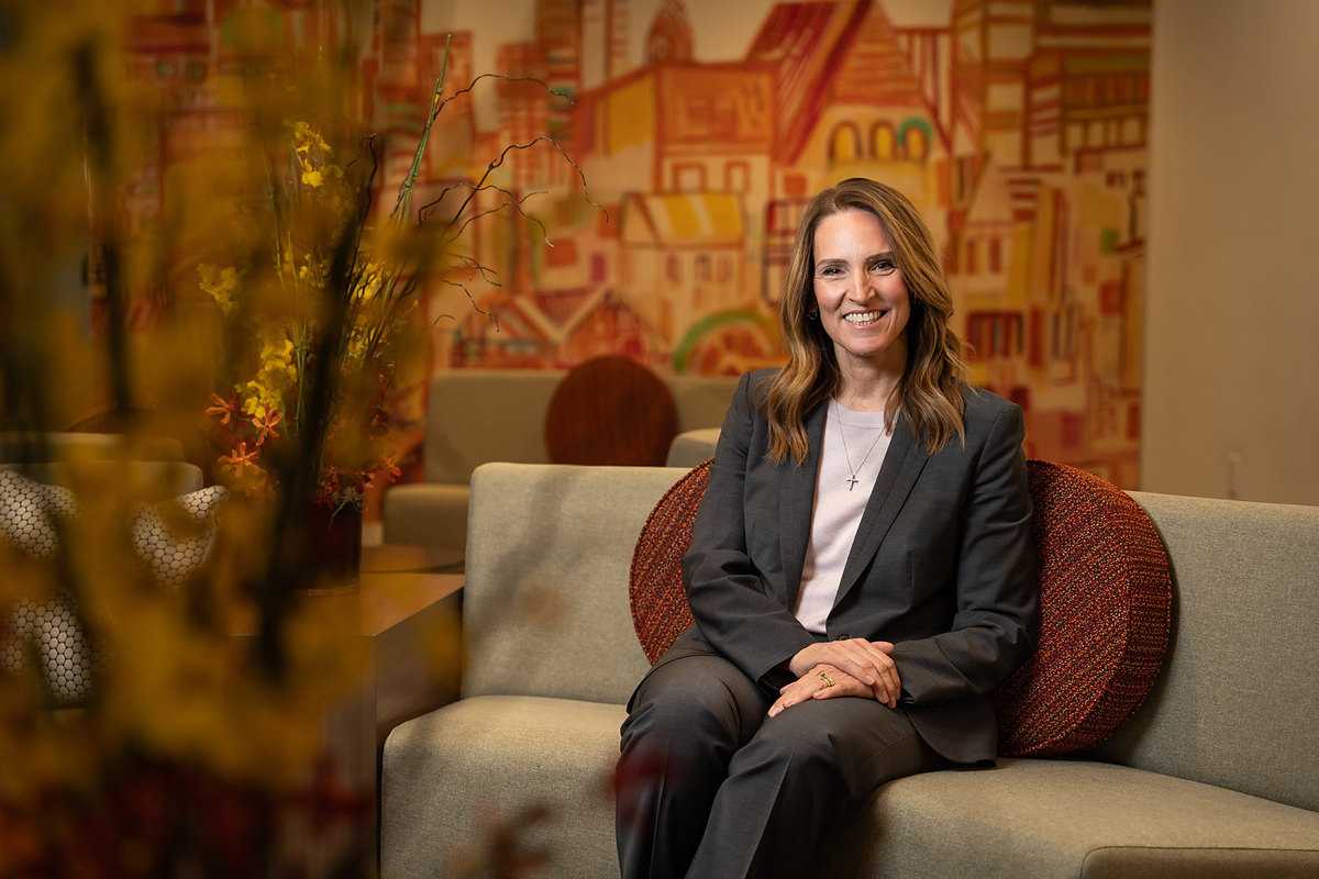 Executive seated on a sofa in front of a colorful office mural